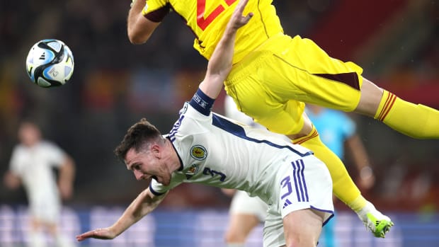 Scotland left-back Andy Robertson pictured falling to the ground after being struck by Spain goalkeeper Unai Simon during a game in October 2023