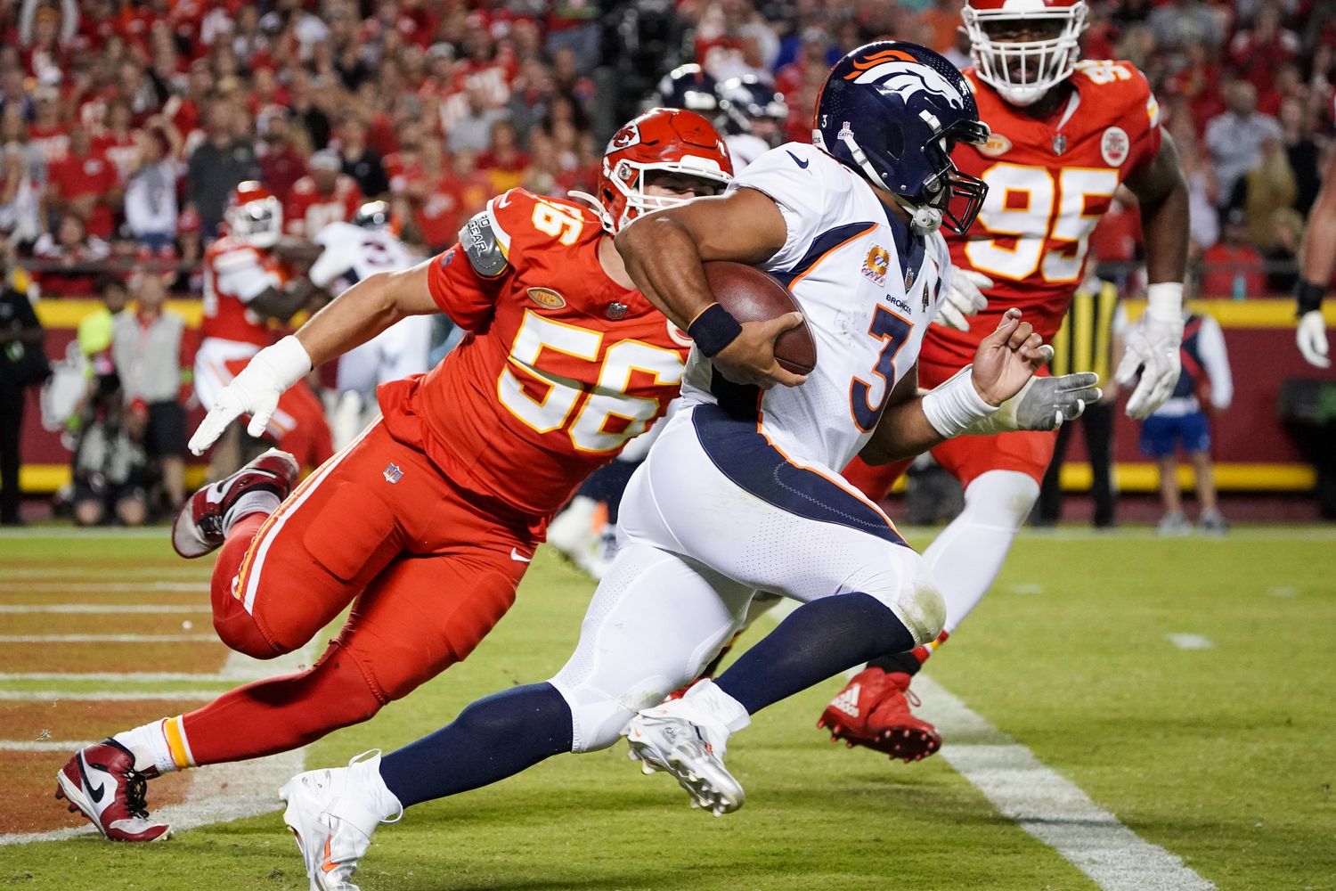 Oct 12, 2023; Kansas City, Missouri, USA; Denver Broncos quarterback Russell Wilson (3) runs the ball as Kansas City Chiefs defensive end George Karlaftis (56) chases during the second half at GEHA Field at Arrowhead Stadium. Mandatory Credit: Denny Medley-USA TODAY Sports  