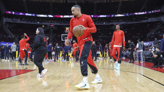 Rockets forward Dillon Brooks dribbles a ball in warmups before a game.