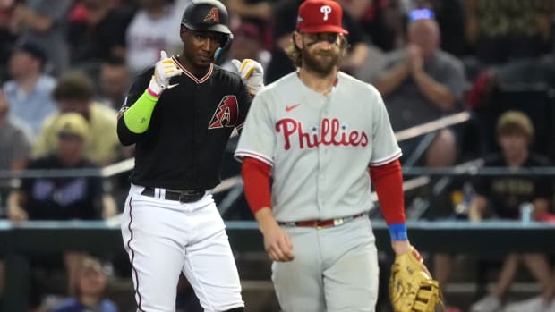 Arizona Diamondbacks shortstop Geraldo Perdomo (left) reacts after hitting a single during the seventh inning as Philadelphia Phillies first baseman Bryce Harper (right) looks on in game four of the NLCS of the 2023 MLB playoffs at Chase Field in Phoenix on Oct. 20, 2023.