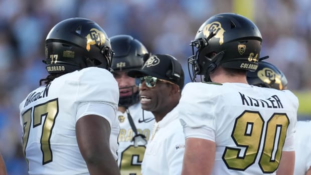 Colorado Buffaloes head coach Deion Sanders talks with offensive tackle Kareem Harden (77) in the first half against the UCLA Bruins at Rose Bowl