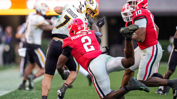 Missouri Tigers running back Cody Schrader (7) is grabbed by the facemark by Georgia Bulldogs linebacker Smael Mondon Jr. (2) during the second half at Sanford Stadium.
