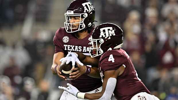 Nov 11, 2023; College Station, Texas, USA; Texas A&M Aggies quarterback Jaylen Henderson (16) hands off the ball to running back Amari Daniels (4) during the first quarter at Kyle Field.
