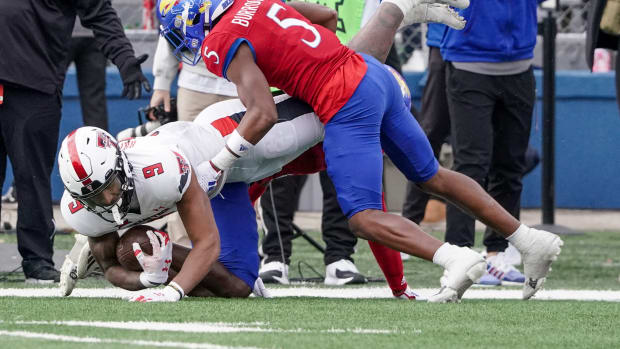 Nov 11, 2023; Lawrence, Kansas, USA; Kansas Jayhawks safety O.J. Burroughs (5) tackles Texas Tech Red Raiders wide receiver Jerand Bradley (9) during the second half at David Booth Kansas Memorial Stadium. Mandatory Credit: Denny Medley-USA TODAY Sports  