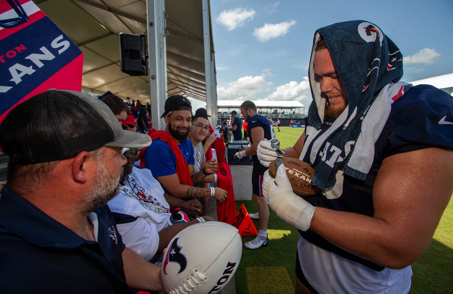 OT Austin Deculus signs an autograph for a fan at Texans' training camp