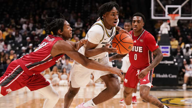 Missouri Tigers guard Anthony Robinson II (14) dribbles the ball and is fouled by SIU Edwardsville Cougars guard Brian Taylor II (11) during the first half at Mizzou Arena.