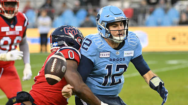 Nov 11, 2023; Toronto, Ontario, CAN; Toronto Argonauts quarterback Chad Kelly (12) fumbles the ball after being tackled by Montreal Alouettes defensive end Shawn Lemon (0) in the first half at BMO Field. Mandatory Credit: Dan Hamilton-USA TODAY Sports