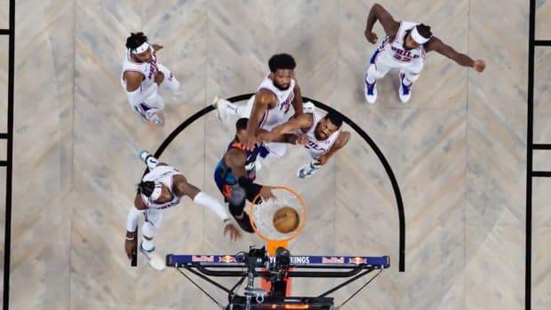 Brooklyn Nets guard Lonnie Walker dunks over several Philadelphia 76ers defenders in a game on Nov. 19, 2023.