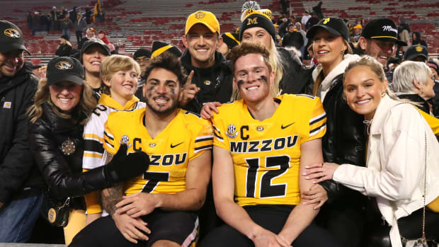Nov 24, 2023; Fayetteville, Arkansas, USA; Missouri Tigers running back Cody Schrader (7) and quarterback Brady Cook (12) pose with fans after the game against the Arkansas Razorbacks at Donald W. Reynolds Razorback Stadium. Missouri won 48-14. Mandatory Credit: Nelson Chenault-USA TODAY Sports