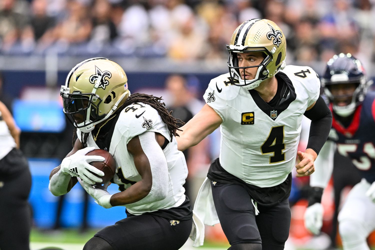 Saints quarterback Derek Carr hands the ball off to running back Alvin Kamara during New Orleans's 20-13 loss to the Texans on Oct. 15, 2023.