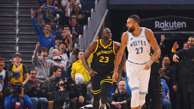 Nov 12, 2023; San Francisco, California, USA; Golden State Warriors forward Draymond Green (23) celebrates behind Minnesota Timberwolves center Rudy Gobert (27) after scoring a three point basket during the first quarter at Chase Center.