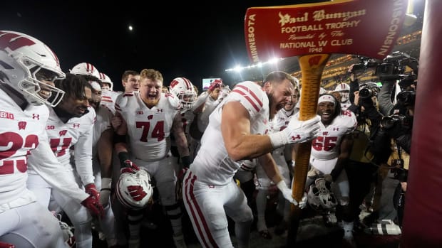 Nov 25, 2023; Minneapolis, Minnesota, USA; Wisconsin tight end Hayden Rucci (87) and teammates celebrate with the Paul Bunyan Football Trophy ceremonial axe to act out cutting down the goalposts after defeating the Minnesota Golden Gophers at Huntington Bank Stadium. Wisconsin won 28-14. Mandatory Credit: Mark Hoffman/Milwaukee Journal Sentinel via USA TODAY NETWORK