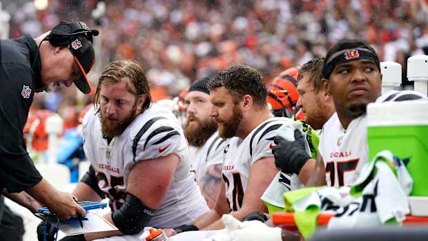 Cincinnati Bengals offensive line coach Frank Pollack, left, talks with Cincinnati Bengals guard Alex Cappa (65), Cincinnati Bengals guard Max Scharping (74) and Cincinnati Bengals guard Cordell Volson (67) in the fourth quarter of an NFL football game between the Cincinnati Bengals and Cleveland Browns, Sunday, Sept. 10, 2023, at Cleveland Browns Stadium in Cleveland.  
