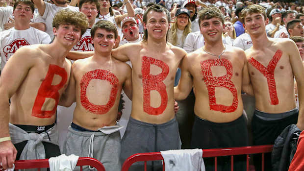 Fans at basketball game celebrating Bobby Petrino's return