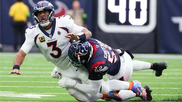 Russell Wilson is hit by Texans defense.
