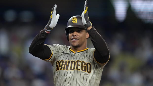 Padres outfielder Juan Soto signals to the dugout while on second base during a game.
