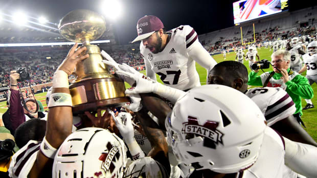 Mississippi State Bulldogs players react with the Egg Bowl trophy after defeating the Mississippi Rebels at Vaught-Hemingway Stadium in 2018.