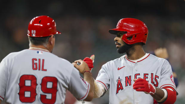 September 4, 2012; Oakland, CA, USA; Los Angeles Angels third baseman Alberto Callaspo (6) is congratulated by designated hitter Albert Pujols (5) and the coaching staff after scoring on a RBI-single by center fielder Mike Trout (not pictured) during the fifth inning against the Oakland Athletics at O.co Coliseum. Mandatory Credit: Kyle Terada-USA TODAY Sports  