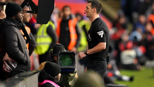 Referee Andrew Madley pictured looking at the VAR monitor during a Premier League game between Crystal Palace and Liverpool in December 2023