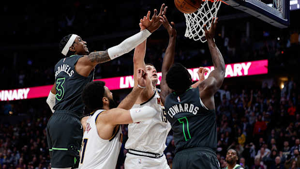 Jan 18, 2023; Denver, Colorado, USA; Denver Nuggets center Nikola Jokic (15) battles for a rebound with Minnesota Timberwolves forward Jaden McDaniels (3) and guard Anthony Edwards (1) as guard Jamal Murray (27) defends in the fourth quarter at Ball Arena.