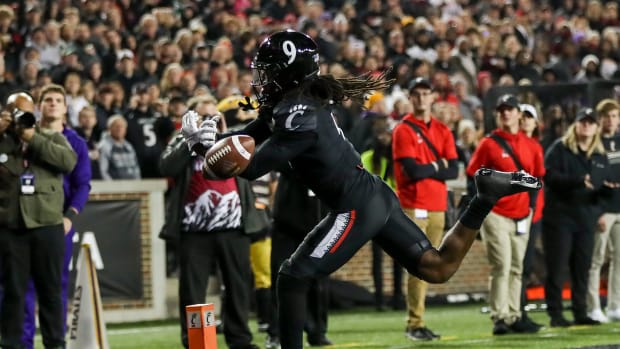 Nov 11, 2022; Cincinnati, Ohio, USA; Cincinnati Bearcats cornerback Arquon Bush (9) attempts to intercept the ball against the East Carolina Pirates in the first half at Nippert Stadium. Mandatory Credit: Katie Stratman-USA TODAY Sports  