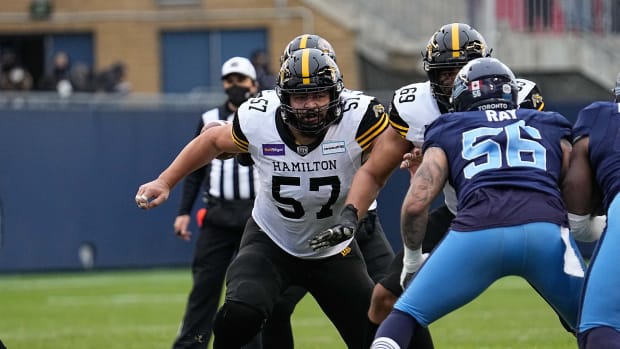 Dec 5, 2021; Toronto, Ontario, CAN; Hamilton Tiger-Cats offensive lineman Brandon Revenberg (57) sets up to block against Toronto Argonauts defensive lineman Shane Ray (56) during the Canadian Football League Eastern Conference Final game at BMO Field. Mandatory Credit: John E. Sokolowski-USA TODAY Sports  