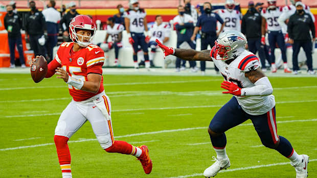 Oct 5, 2020; Kansas City, Missouri, USA; Kansas City Chiefs quarterback Patrick Mahomes (15) rolls out to pass as New England Patriots linebacker Anfernee Jennings (58) defends at Arrowhead Stadium. Mandatory Credit: Jay Biggerstaff-USA TODAY Sports  
