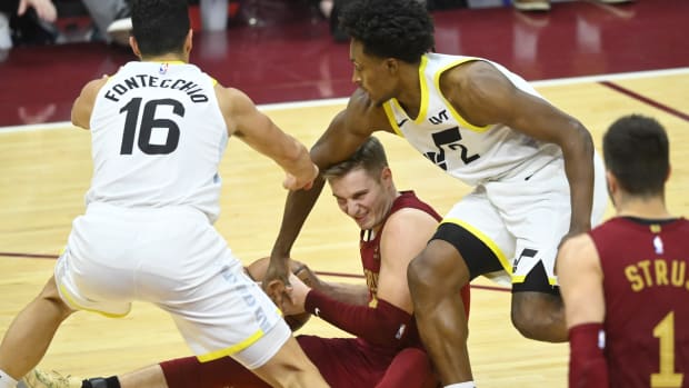 Dec 20, 2023; Cleveland, Ohio, USA; Utah Jazz forward Simone Fontecchio (16) and guard Collin Sexton (2) defend Cleveland Cavaliers guard Sam Merrill (5) in the fourth quarter at Rocket Mortgage FieldHouse.