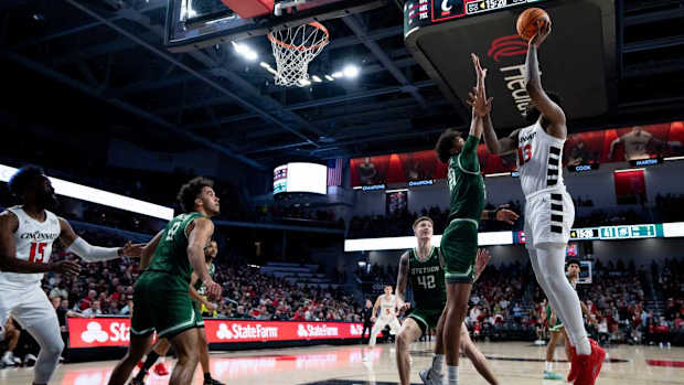 Cincinnati Bearcats forward Jamille Reynolds (13) hits a basket over Stetson Hatters center Aubin Gateretse (21) in the second half of the basketball game between Cincinnati Bearcats and Stetson Hatters at Fifth Third Arena in Cincinnati on Friday, Dec. 22, 2023