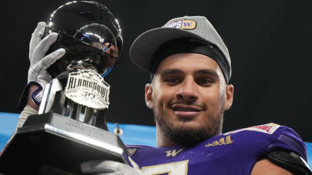 Washington defensive end Braelon Trice holds the Alamo Bowl trophy.