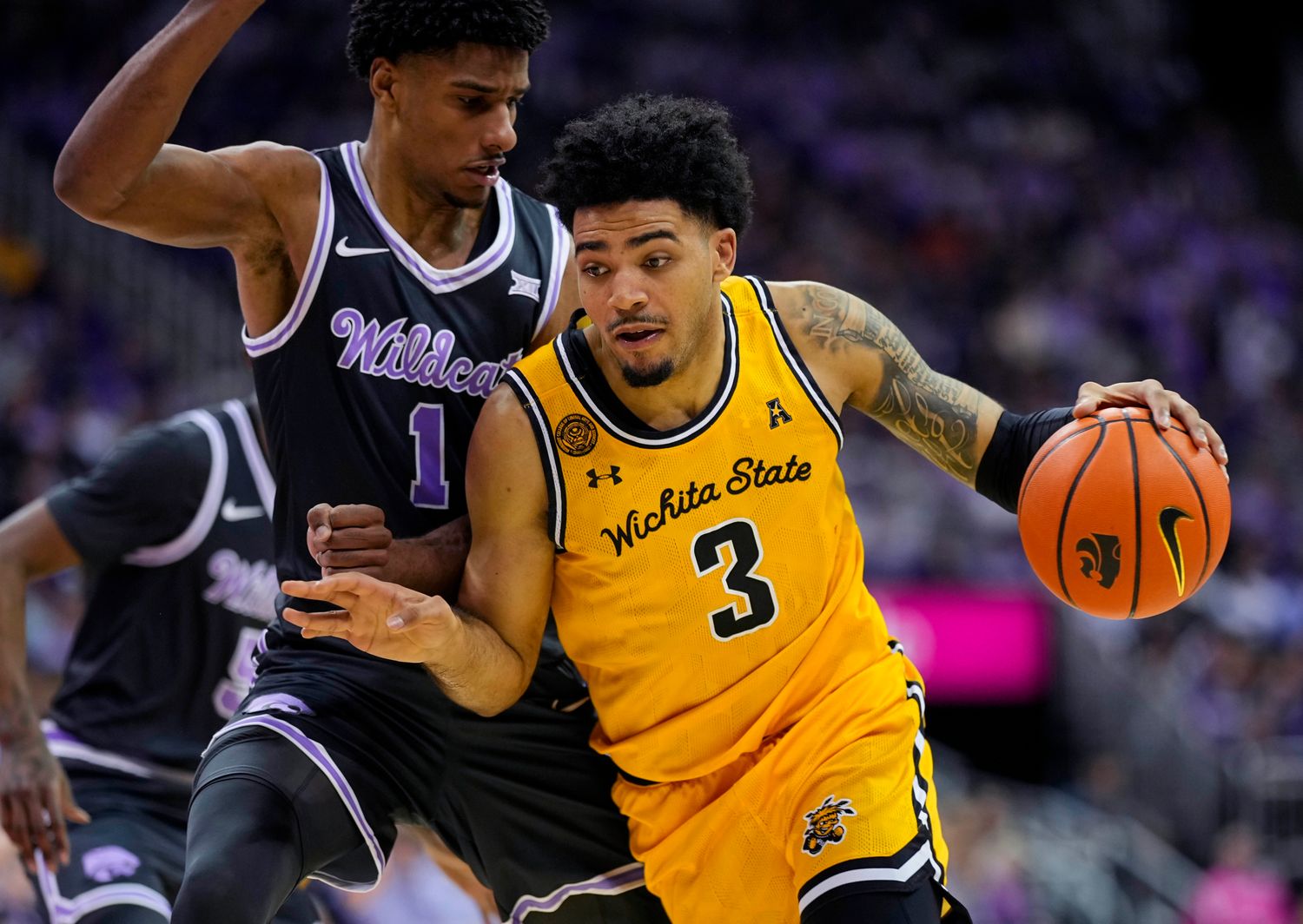 Dec 21, 2023; Kansas City, Missouri, USA; Wichita State Shockers forward Ronnie DeGray III (3) drives against Kansas State Wildcats forward David N'Guessan (1) during the second half at T-Mobile Center. Mandatory Credit: Jay Biggerstaff-USA TODAY Sports  