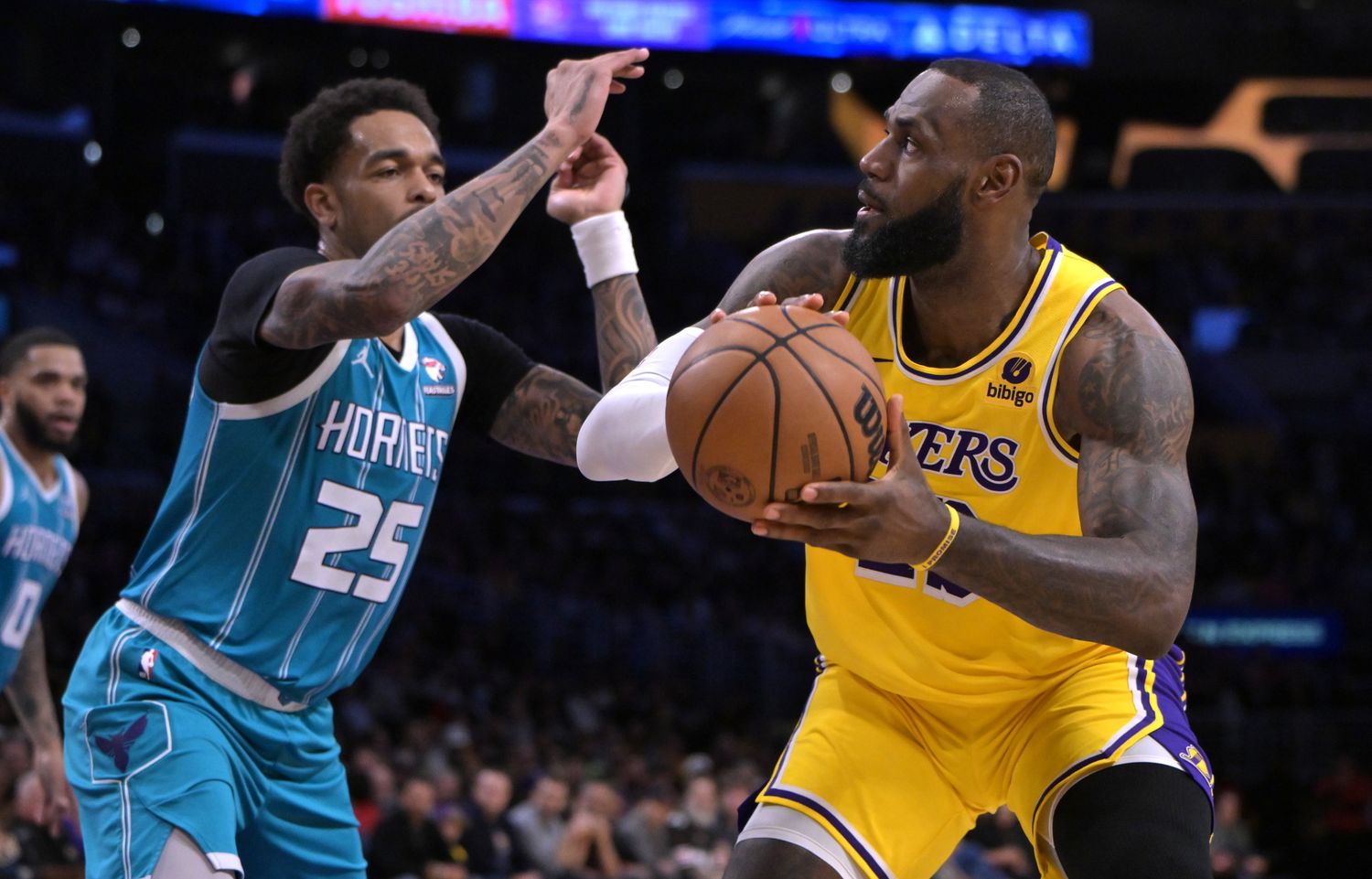 Charlotte Hornets forward P.J. Washington (25) defends Los Angeles Lakers forward LeBron James (23) in the first half at Crypto.com Arena in Los Angeles on Dec. 28, 2023.