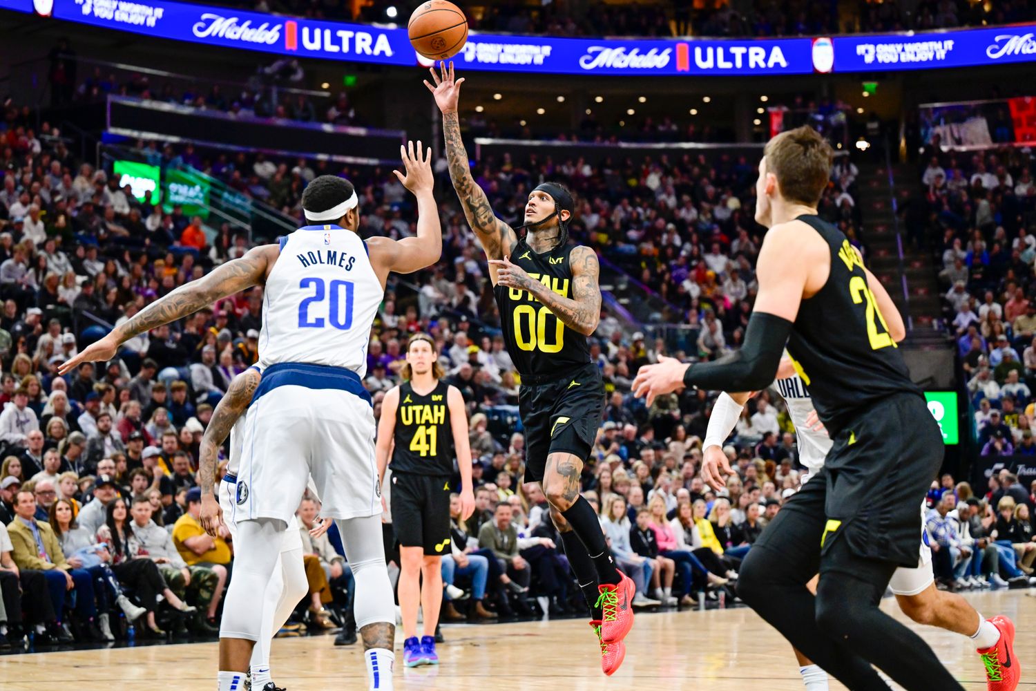 Jan 1, 2024; Salt Lake City, Utah, USA; Utah Jazz guard Jordan Clarkson (00) takes a shot over Dallas Mavericks forward Richaun Holmes (20) during the second half at the Delta Center. Mandatory Credit: Christopher Creveling-USA TODAY Sports