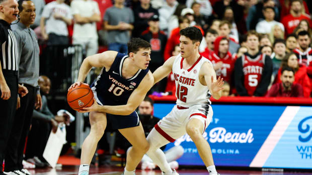 Virginia Cavaliers guard Taine Murray (10) dribbles the ball guarded by North Carolina State Wolfpack guard Michael O'Connell (12) during the first half at PNC Arena.