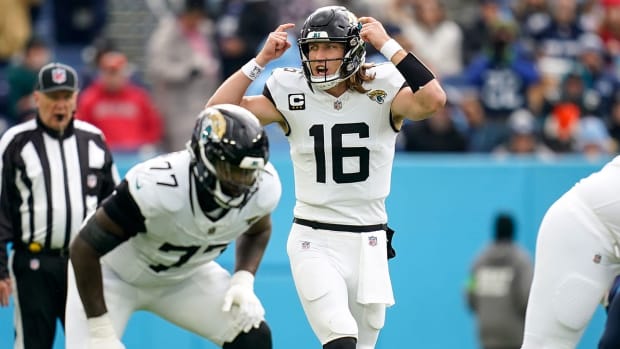 Trevor Lawrence signals by pointing to his helmet before taking a snap