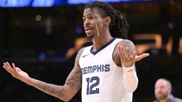 Grizzlies guard Ja Morant holds his hands up after a play against the Lakers.