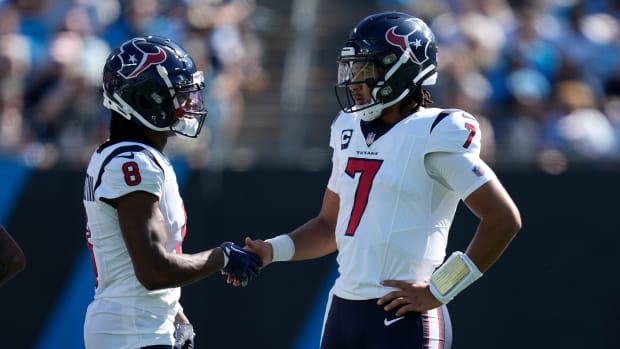 Houston Texans wide receiver John Metchie III (8) shakes hands with quarterback C.J. Stroud (7) during a time out to check for a touchdown run during the second quarter against the Carolina Panthers at Bank of America Stadium.