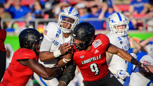 Air Force Falcons quarterback Haaziq Daniels (4) reacts to being hit by Louisville Cardinals linebacker C.J. Avery (9) during the First Responder Bowl at Gerald J. Ford Stadium in Dallas in 2021.