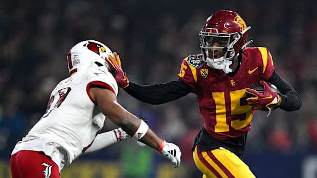 Dec 27, 2023; San Diego, CA, USA; USC Trojans wide receiver Dorian Singer (15) stiff arms Louisville Cardinals defensive back Devin Neal (27) during the first half at Petco Park. Mandatory Credit: Orlando Ramirez-USA TODAY Sports