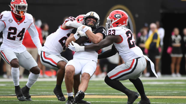 Oct 14, 2023; Nashville, Tennessee, USA; Vanderbilt Commodores wide receiver Richie Hoskins (15) is tackled by Georgia Bulldogs defensive back Javon Bullard (22) and defensive back Tykee Smith (23) after a reception during the first half at FirstBank Stadium. (Christopher Hanewinckel / USA TODAY Sports).