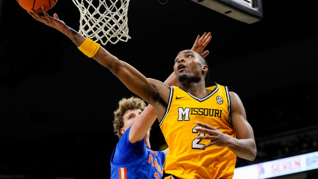 Jan 20, 2024; Columbia, Missouri, USA; Missouri Tigers guard Tamar Bates (2) shoots against Florida Gators center Micah Handlogten (3) during the first half at Mizzou Arena. 