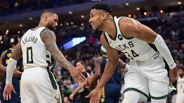 Milwaukee Bucks stars Damian Lillard and Giannis Antetokounmpo high five.