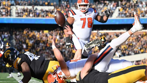 Nov 18, 2023; Iowa City, Iowa, USA; Illinois Fighting Illini quarterback John Paddock (4) fumbles the ball for an eventual safety after a sack by Iowa Hawkeyes defensive end Joe Evans (13) as defensive lineman Deontae Craig (45) and offensive lineman Isaiah Adams (78) look on during the first quarter at Kinnick Stadium. Mandatory Credit: Jeffrey Becker-USA TODAY Sports  