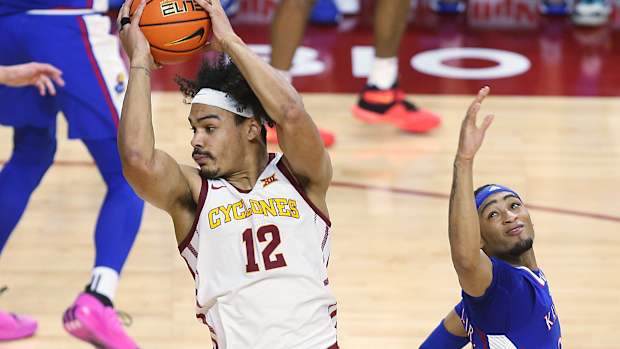 Iowa State Cyclones forward Robert Jones (12) drives to the basket around Kansas Jayhawks guard Dajuan Harris Jr. (3)during the first half in the Big-12 conference showdown of an NCAA college basketball at Hilton Coliseum on Saturday, Jan. 27, 2024, in Ames, Iowa.