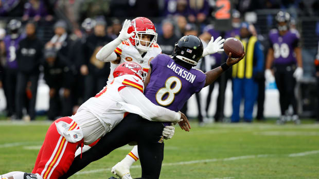 Baltimore Ravens quarterback Lamar Jackson (8) throws the ball around Kansas City Chiefs cornerback Trent McDuffie (22) while being sacked by Chiefs defensive tackle Chris Jones (95) during the first half in the AFC Championship football game at M&T Bank Stadium.