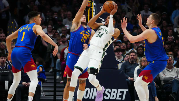 Milwaukee Bucks forward Giannis Antetokounmpo (34) shoots the ball at Denver Nuggets forward Aaron Gordon (50) and forward Michael Porter Jr. (1) and center Nikola Jokic (15) i