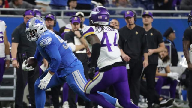 Detroit Lions right tackle Penei Sewell secures a reception against the Minnesota Vikings.