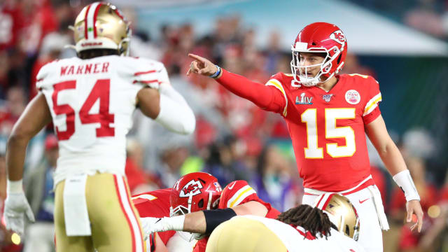Patrick Mahomes prepares for a snap, pointing and gesturing at someone as Fred Warner stands up in front of him