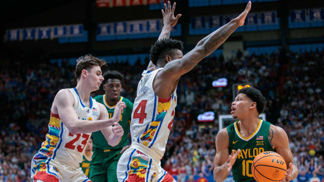 Feb 10, 2024; Lawrence, Kansas, USA; Baylor Bears guard RayJ Dennis (10) looks to pass around Kansas Jayhawks forward K.J. Adams Jr. (24) during the first half at Allen Fieldhouse. Mandatory Credit: William Purnell-USA TODAY Sports  