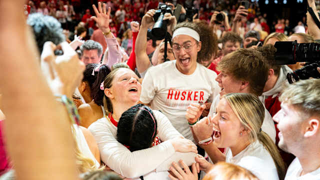 Feb 11, 2024; Lincoln, Nebraska, USA; The Nebraska Cornhuskers celebrate as fans storm the court after defeating the Iowa Hawkeyes at Pinnacle Bank Arena.